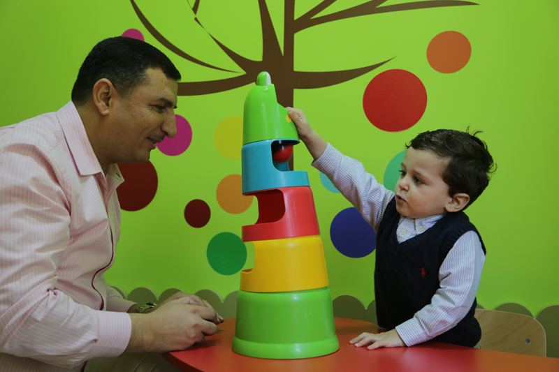 Therapist and boy stacking colourful rings