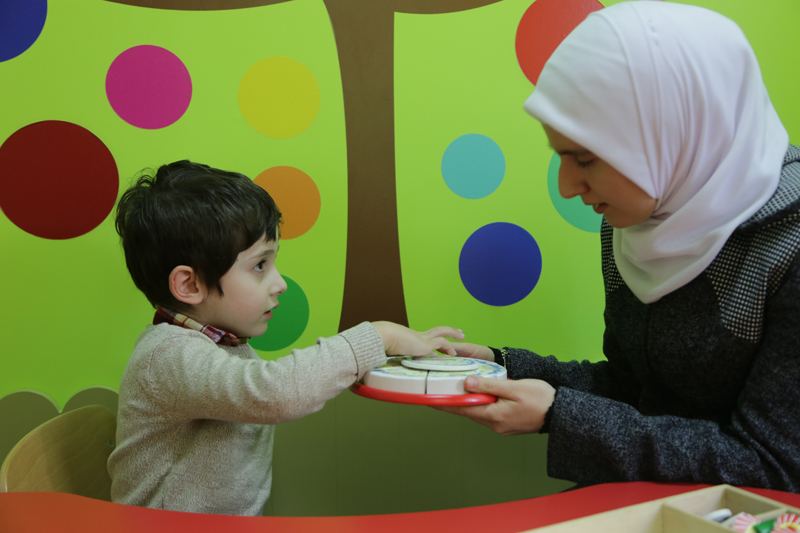 Therapist and child playing at a table